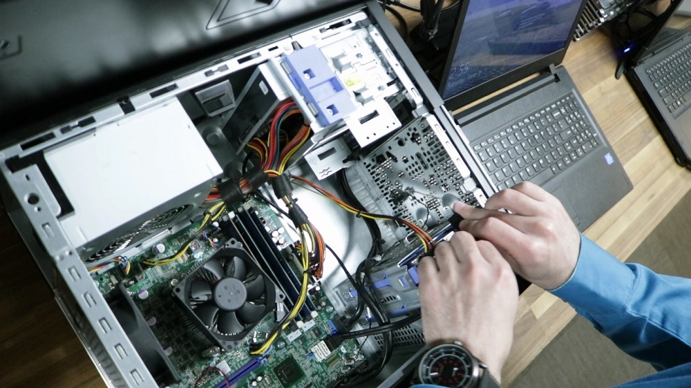 A computer technician handles the internal parts of a PC during a computer repair at Computer Geeks in Springfield, MO